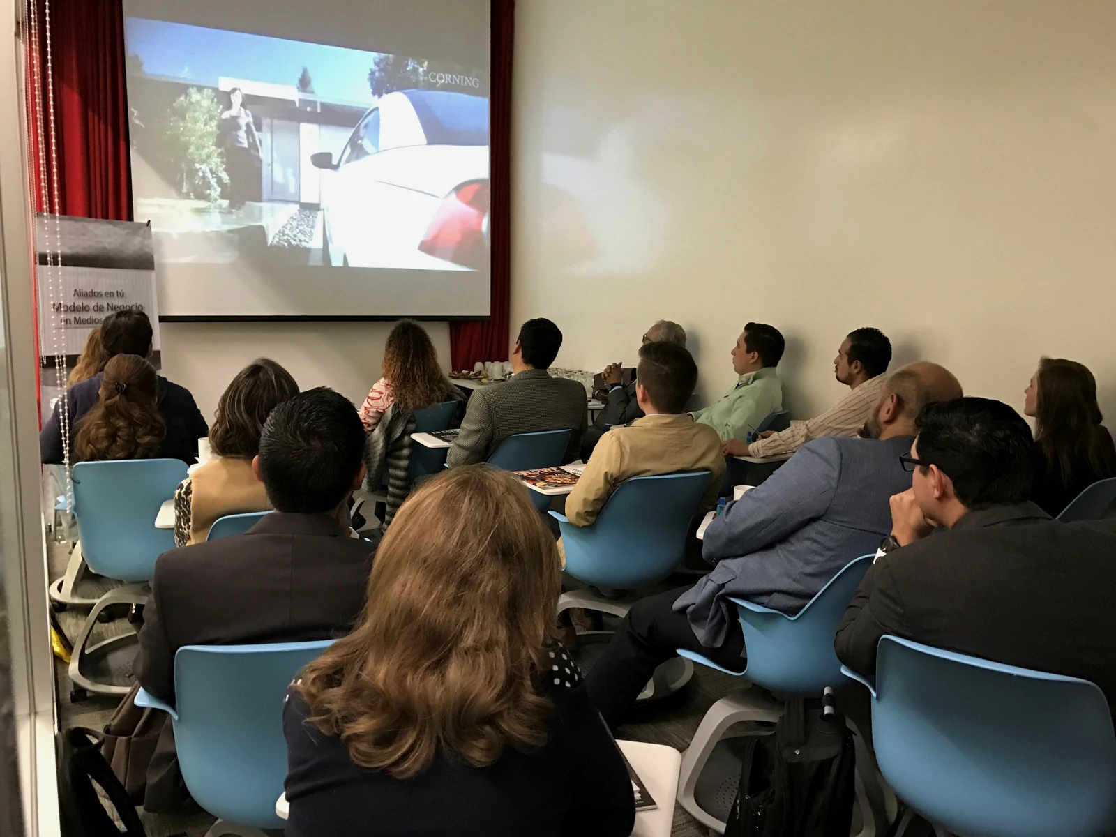 Audiencia observando información proyectada en un espacio corporativo