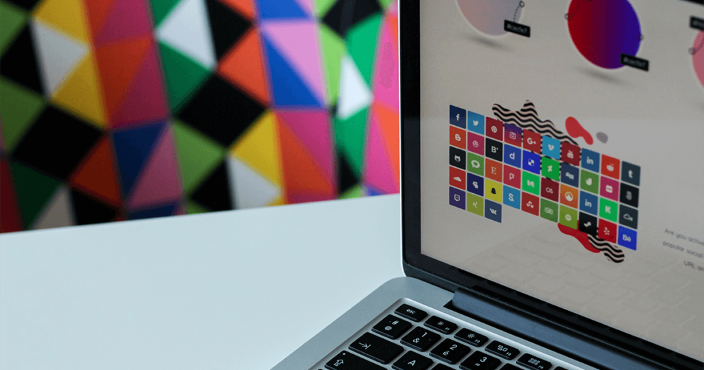 Laptop con fondo colorido y logo de diversas redes sociales, tips elementos de diseño para redes sociales