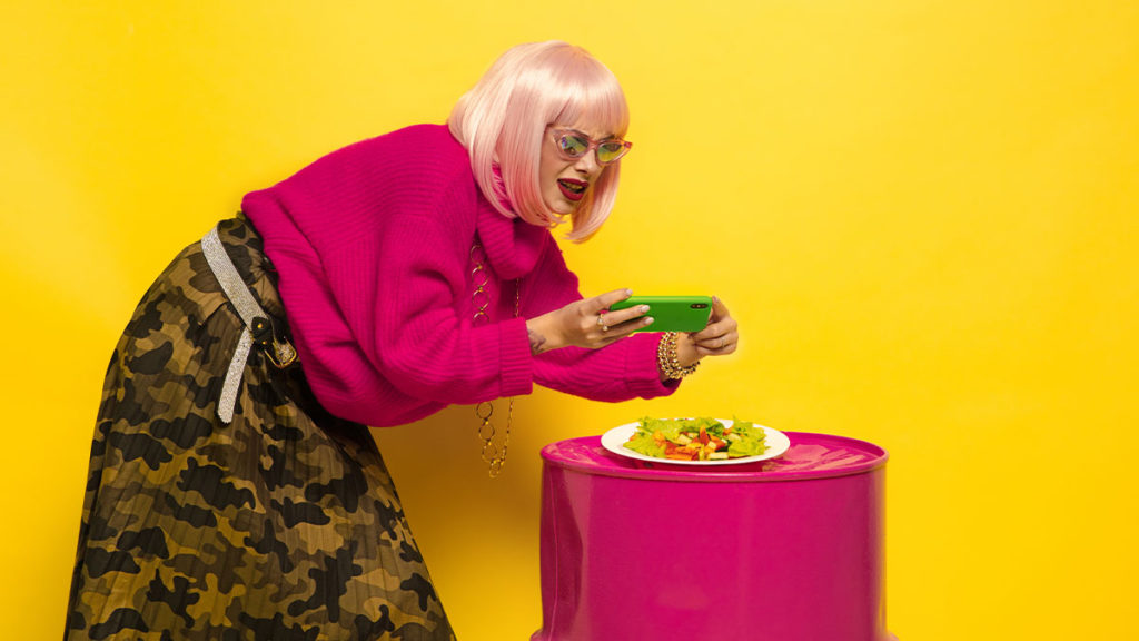 marketing de influencers Influencer de cabello rosa tomando fotos de su comida