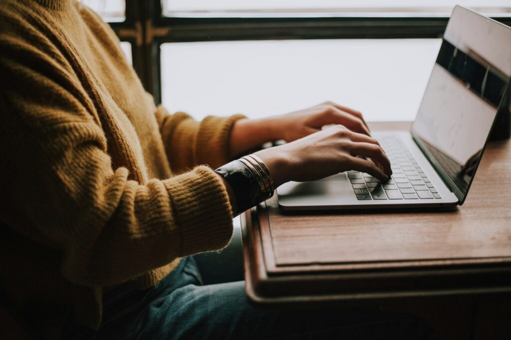 Profesional escribe en una computadora durante una sesión de trabajo